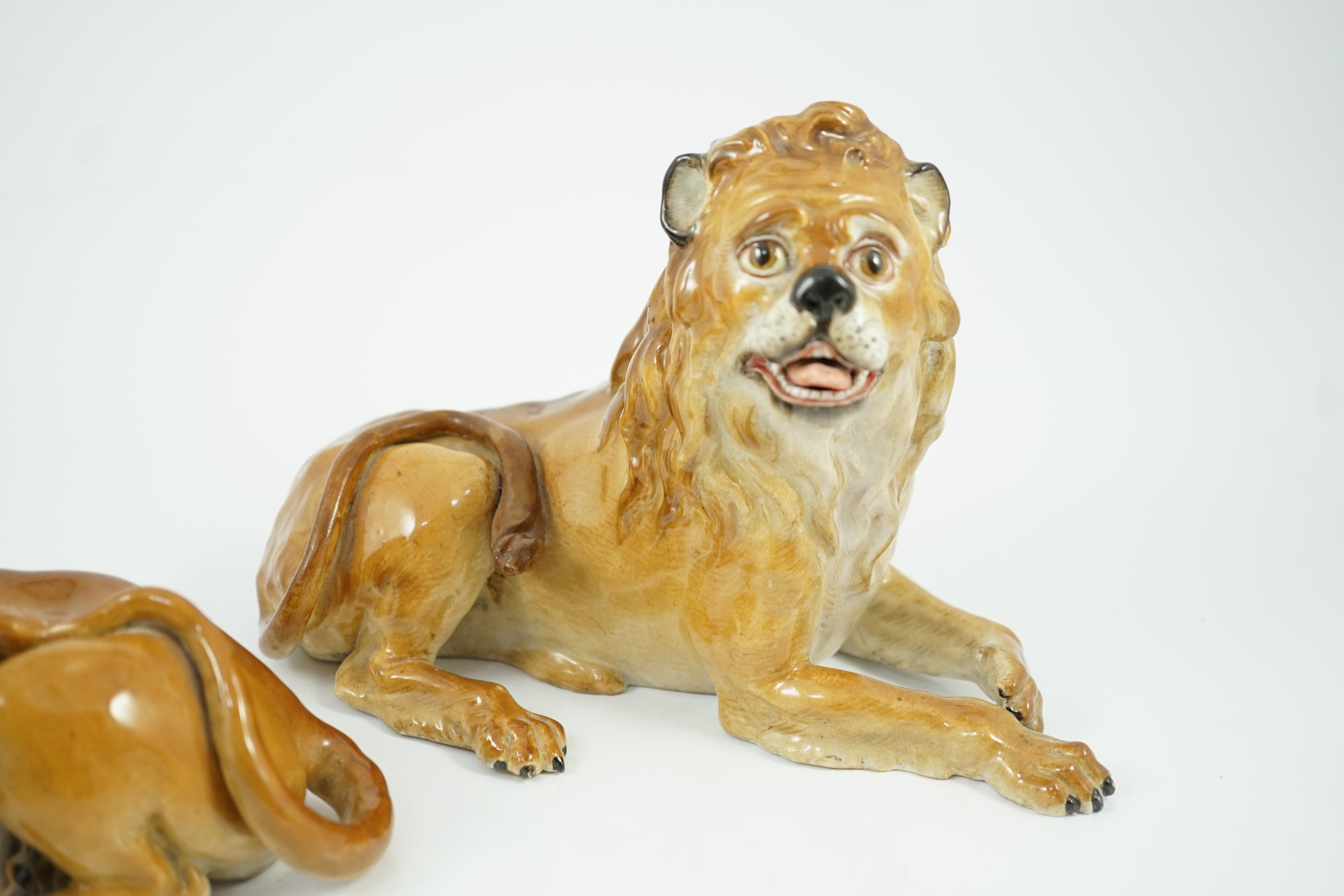 A pair of Meissen figures of a recumbent lion and lioness, 19th century, restoration